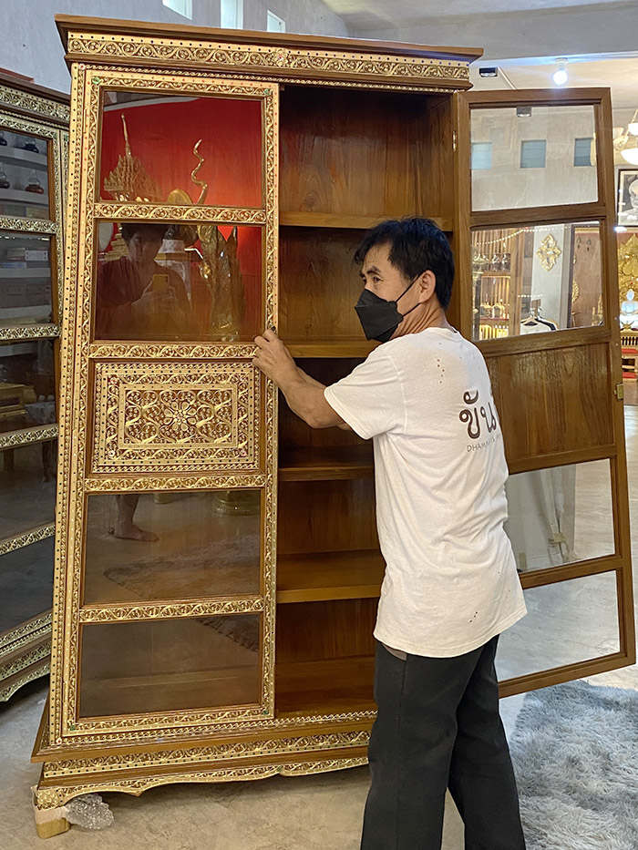 ตู้พระไตรปิฎกไม้สักทั้งหลัง คาดไม้สัก เดินลายเส้นทองกลางตู้ เพิ่มความสวยงามและแข็งแรง อย่างมีเอกลักษณ์